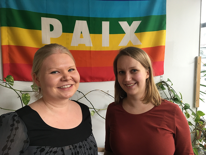 Anni och Tuuli framför en flagga med ordet "Paix".